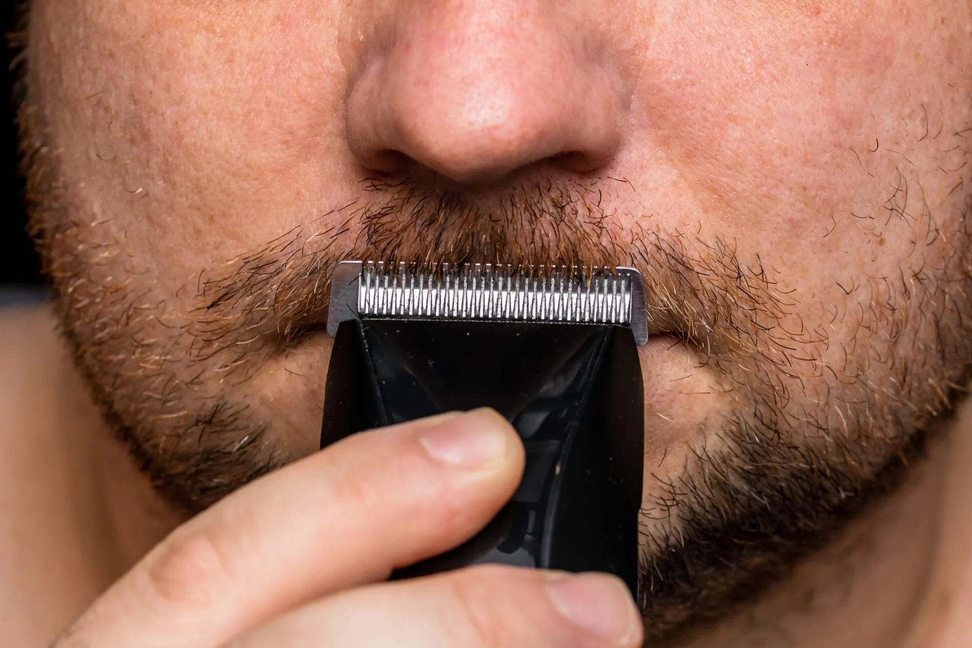Baard wordt met een trimmer kort geknipt