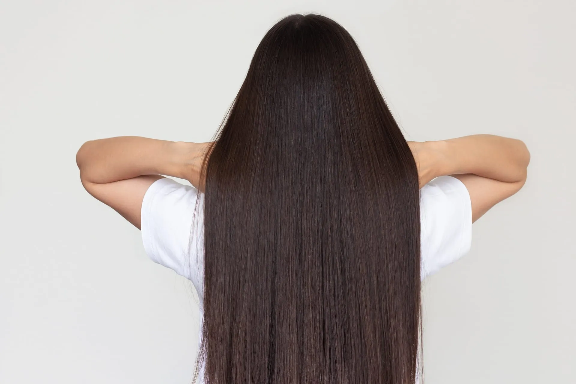 Vrouw met lang, steil haar, van achteren gezien